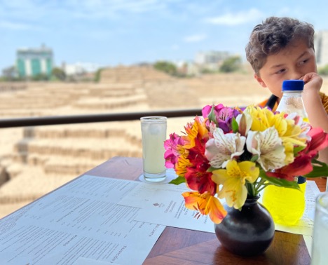 child sitting in restaurant with flower in lima peru