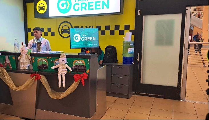 man at counter in taxi green company, one of the best Lima airport to miraflores transport options