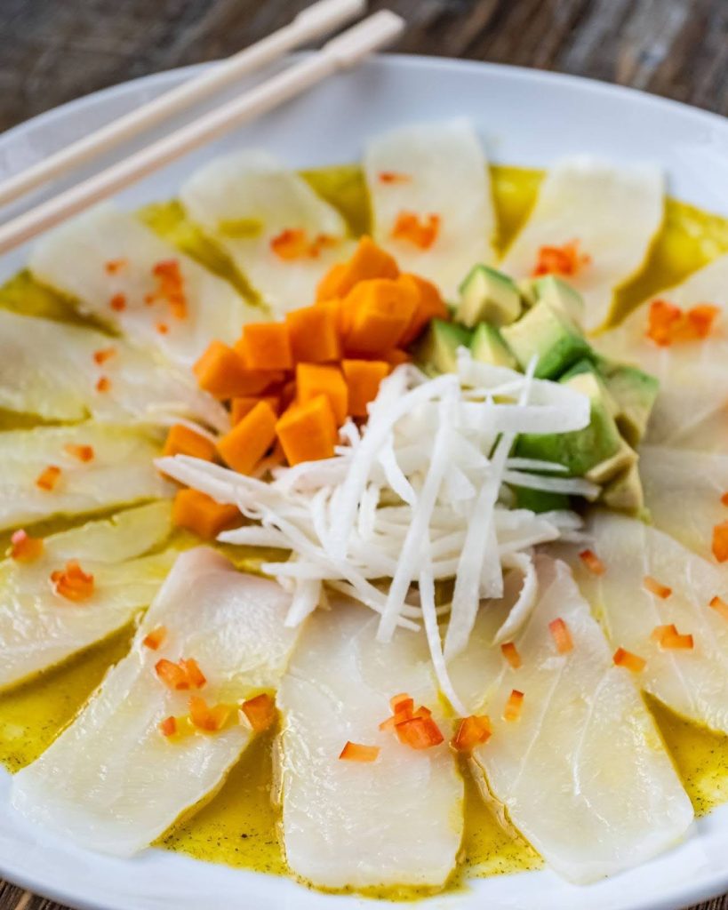 Tiradito, ceviche’s cousin, thin slices of raw fish, topped with bold sauces, aji amarillo, rocoto