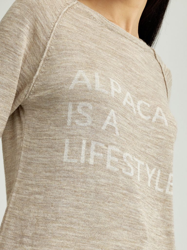 woman wearing alpaca sweater with quote "alpaca is a lifestyle"