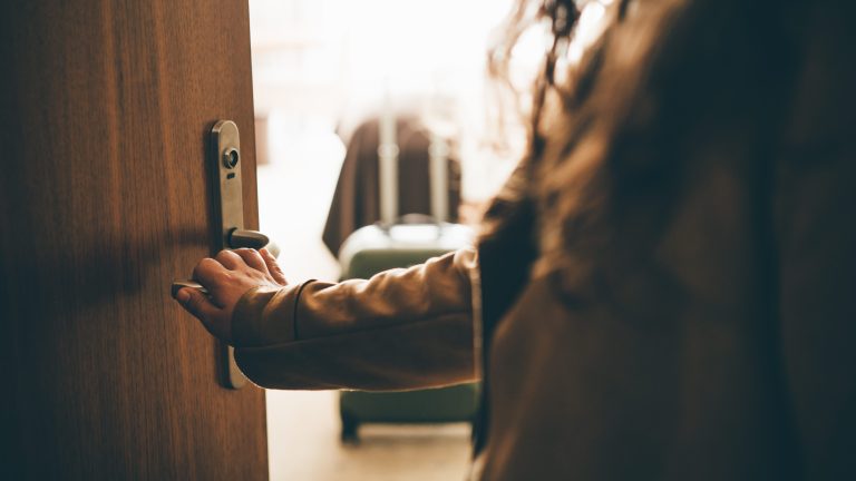 close up of hotel door opening, solo female traveler