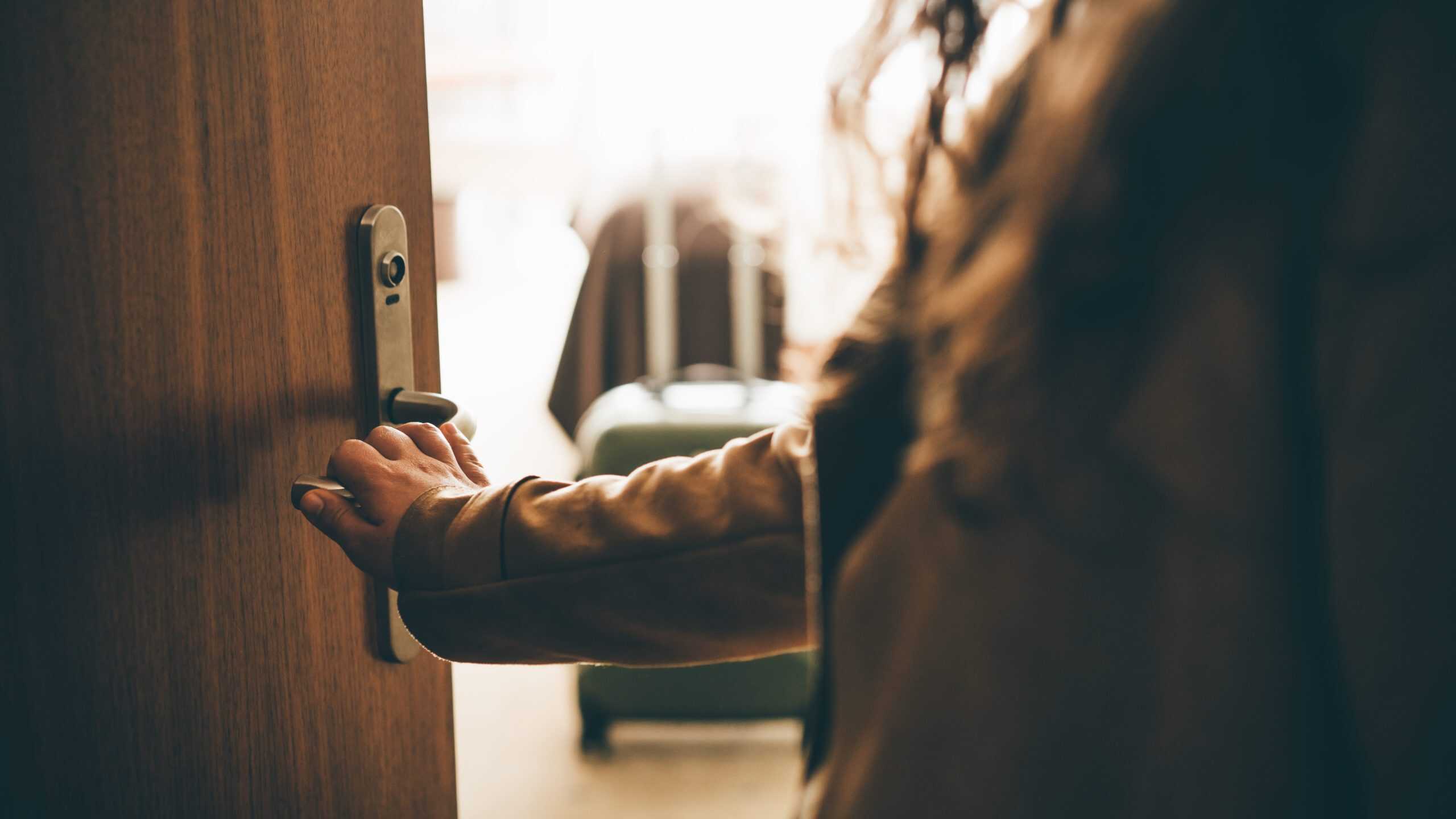 close up of hotel door opening, solo female traveler