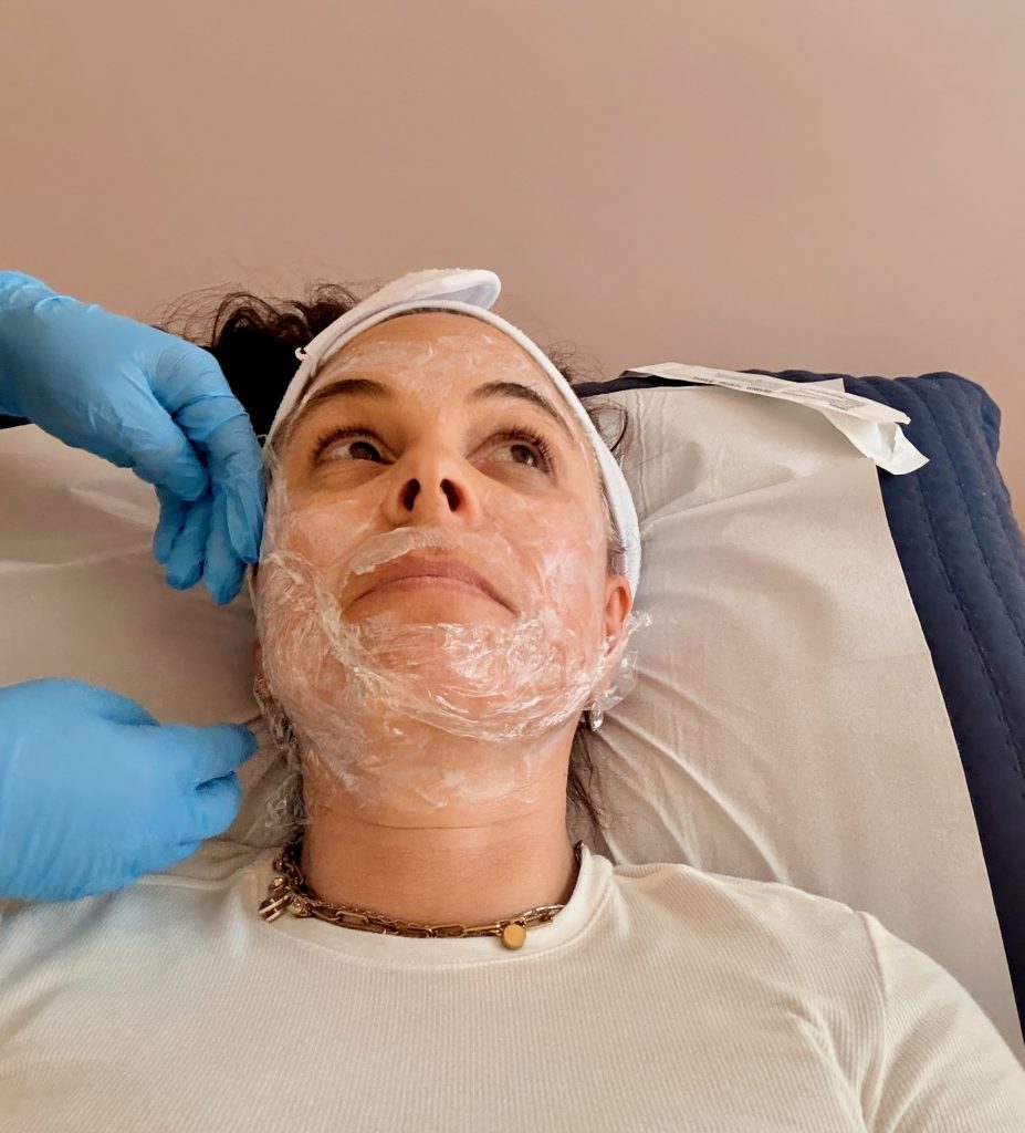 woman getting facial treatment at med spa in lima, doctor applying numbing cream and plastic wrap