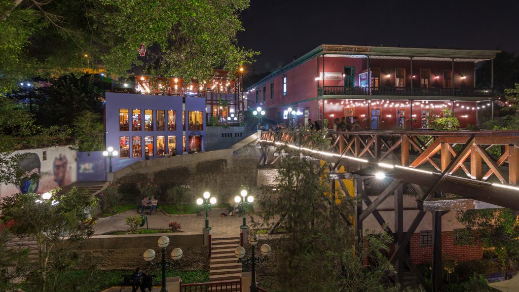 Illuminated Bridge of Sighs night, Tourists and locals crossing in the Barranco district of Lima Peru