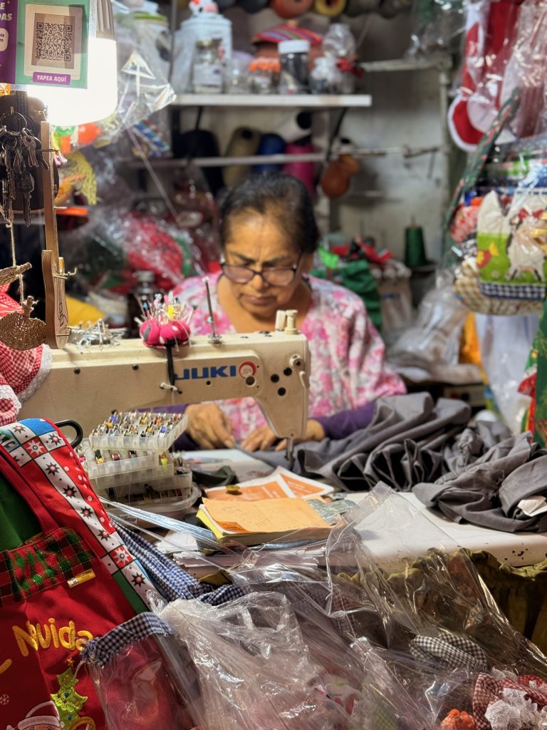 peruvian woman working in custom embroidery shop at Magdalena Market