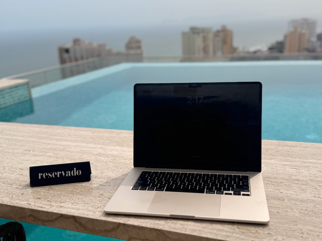 laptop sitting on rooftop bar overlooking pool in souma hotel lima