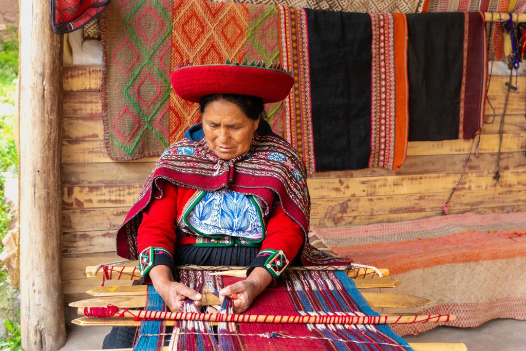 Traditional Peruvian female weaver working on handmade textile design