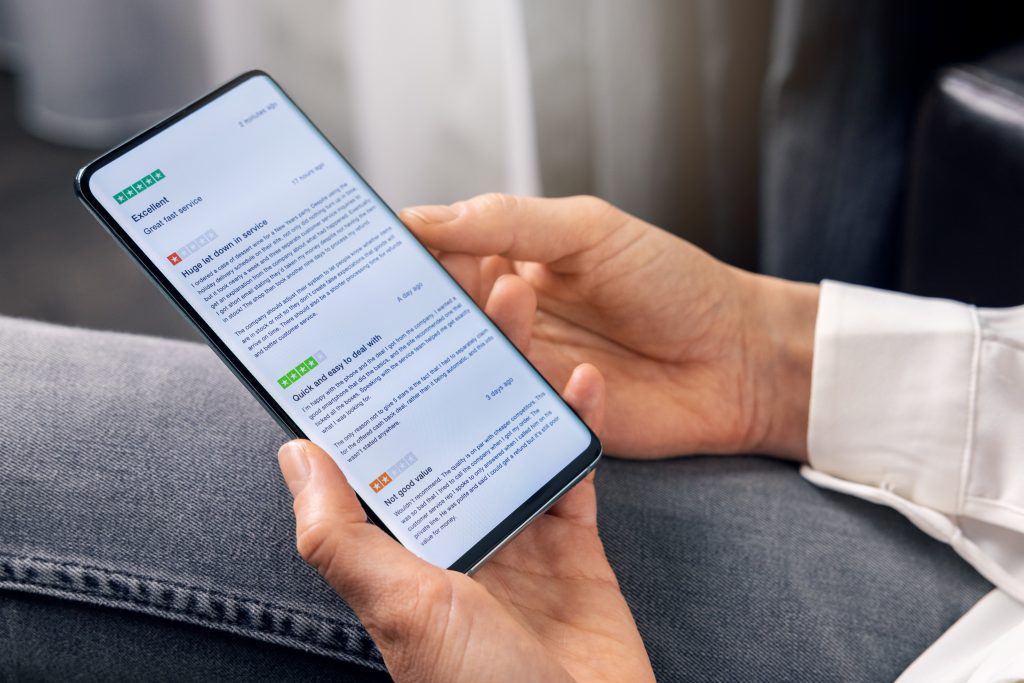 woman using phone to read customer reviews about service quality before online shopping
