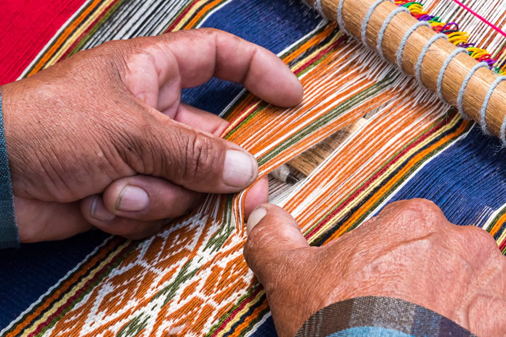 Peruan weaver weaves traditional peruan carpet