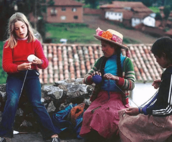 group of children learning to handle peruvian textiles in sacred valley peru