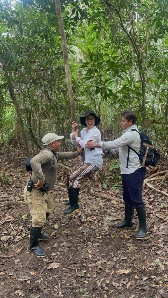 group of people taking turns swinging from a vine in the amazon