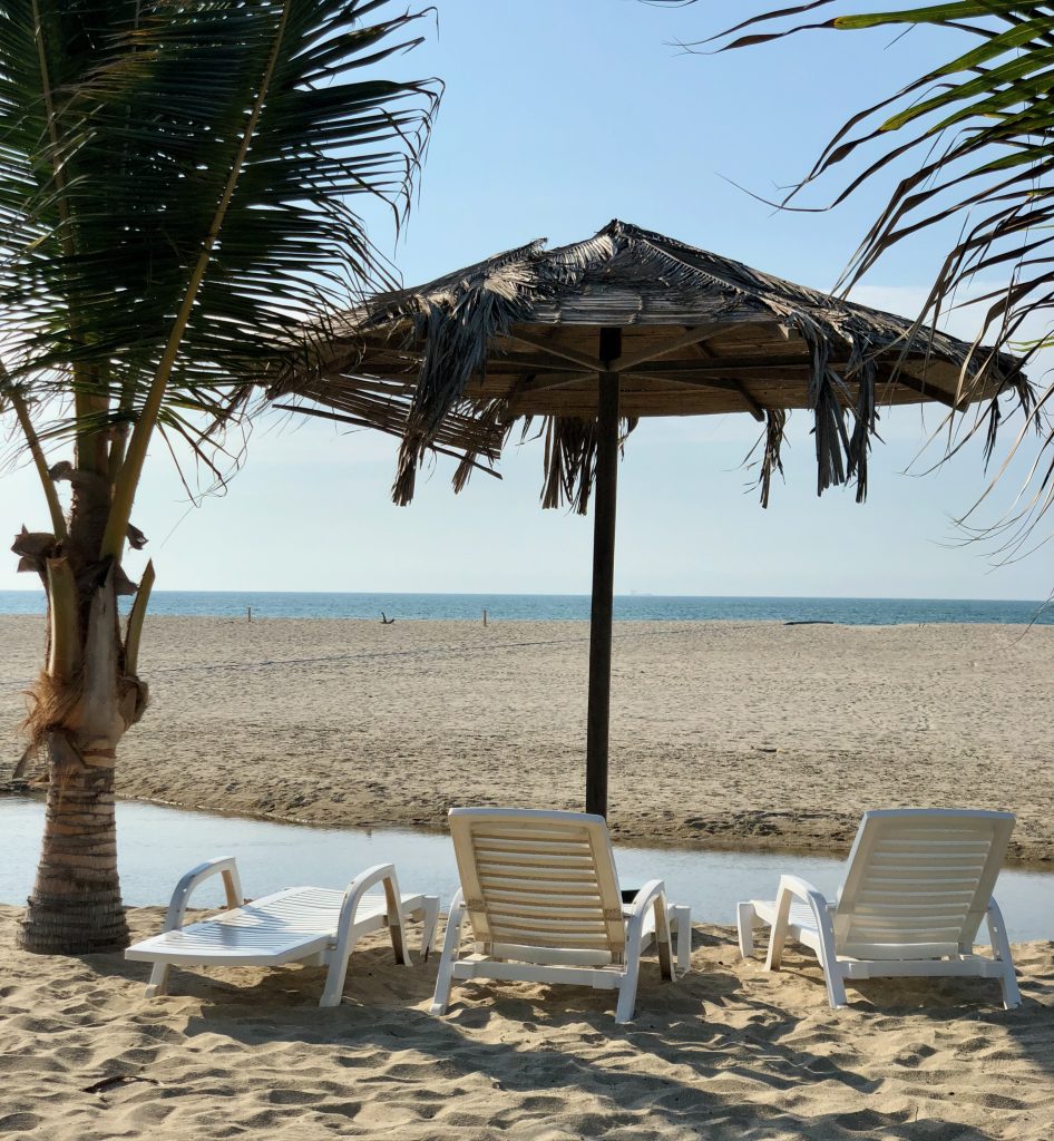chairs and umbrella on a beach in Zorritos peru