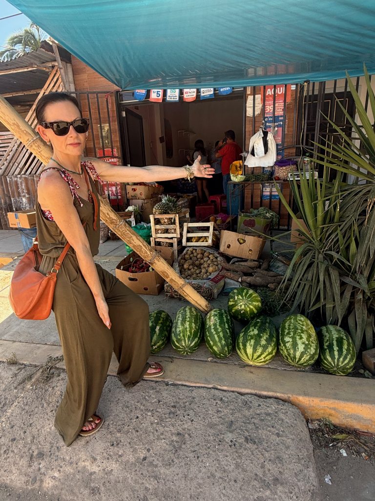 woman posing with watermelons at a fruit juice stand